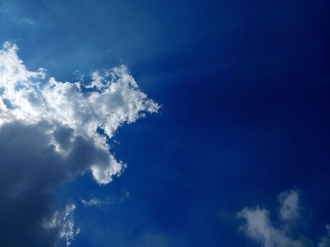 a view of a blue sky dominated by dense and dark white clouds