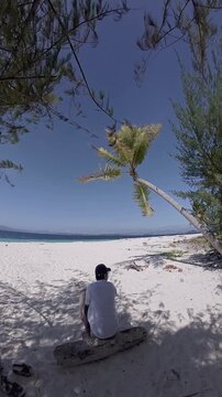 Person Sitting on Beach Under Tree