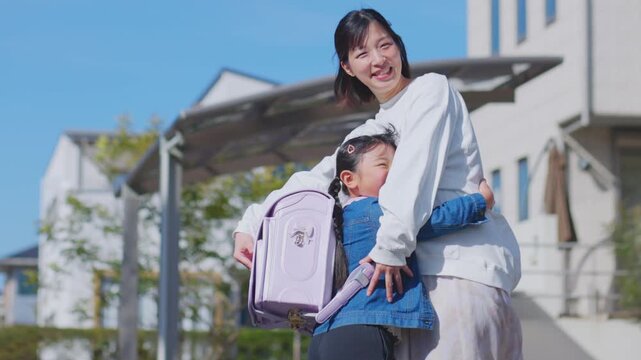 走って母親に抱きつくランドセルの女の子