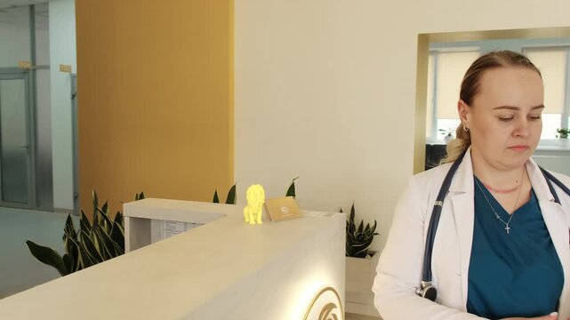 Medical professional carries patient papers to receptionist in modern clinic. Attention to documentation maintains quality care during treatment