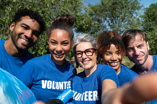 Happy volunteers collecting trash for environmental cleanup, showing community spirit