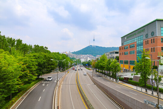 N Seoul Tower and Namsan Mountain Viewed Along a Tree-Lined Urban Road in Seoul, South Korea