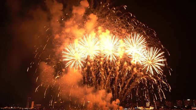 Gold fireworks exploding over city skyline at night