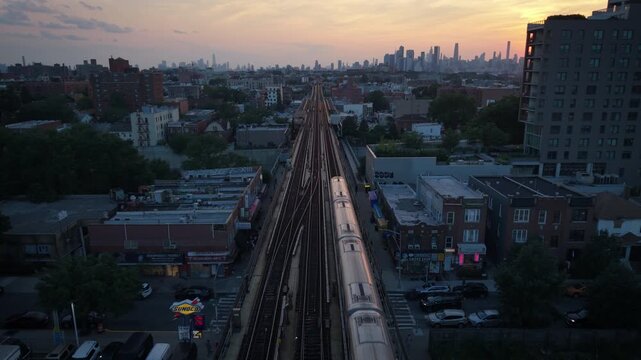 symmetrical wider sunset aerial shot of elevated train in Jackson Heights Queens