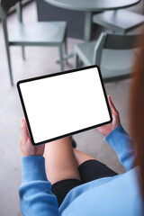 Vertical mockup image of a woman holding digital tablet with blank white desktop screen in cafe © Farknot Architect