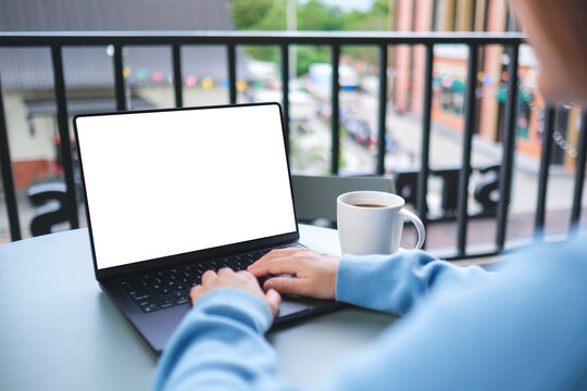 Mockup image of a woman working and typing on laptop computer with blank white desktop screen in cafe
