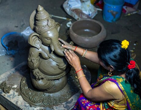 Heritage workshop in Maharashtra where an artisan carefully crafts traditional objects, revealing authentic tools, materials, textures, and everyday work.