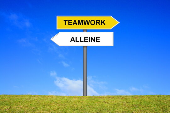 Schild Wegweiser zeigt Alleine und Teamwork