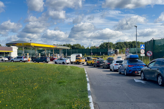 Moscow, Russia. Cars lined up at a busy Rosneft gas station with a yellow canopy and convenience store background. Fuel brands, automotive services, convenience retail, industry marketing