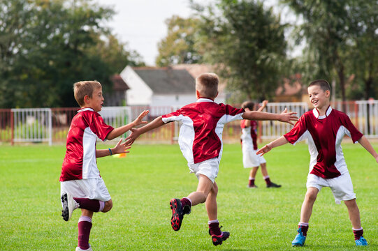 Young Boys Playing Soccer on a Grass Field