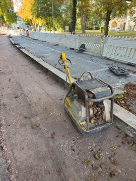Plate Compactor at an Urban Path Construction Site &ndash; Roadworks, Ground Compaction and Infrastructure Development Vertical