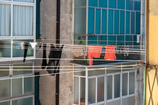 Panni stesi tra edifici residenziali con balconi e finestre. Scena urbana quotidiana ideale per temi vita reale, Mediterraneo, architettura e atmosfera di quartiere.