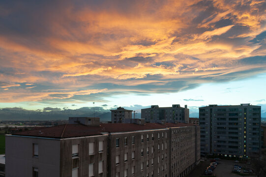 Scena urbana al tramonto con palazzi in silhouette, cielo ricco di colori e nuvole luminose. Ideale per temi cityscape, atmosfera, paesaggio urbano, tramonto e fotografia ambientale.