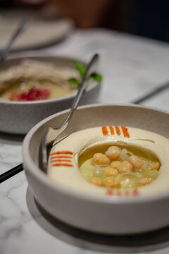 Chickpeas hummus served on a small plate in a restaurant
