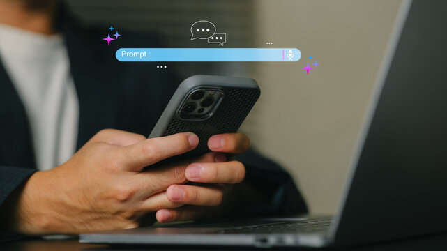 Person Using Smartphone with Chatbot Interface on Laptop in Modern Workspace