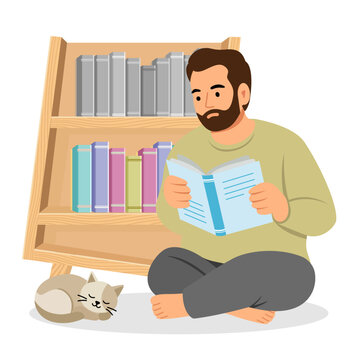 Man Reading Book at Home Sitting on Floor with Cat near Bookshelf