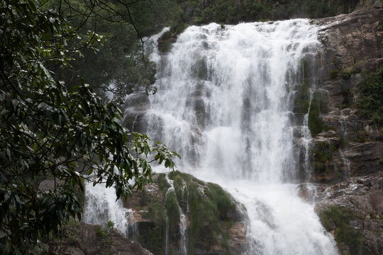 Aerial view of the cascading waterfall at Chapada dos Veadeiros surrounded by lush green vegetation and rocky cliffs in Alto Paraiso de Goias, Goias, Brazil.
