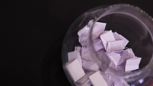 Traditional Indian Parchi Game Paper Slips Stored in Transparent Glass Container