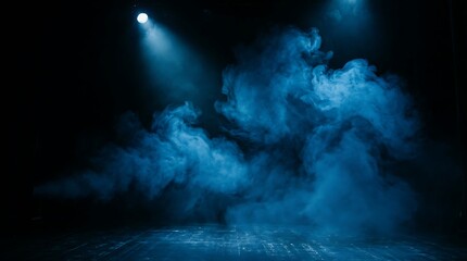 Fototapeta premium Bright blue spotlight shining on stage smoke in a dark theater