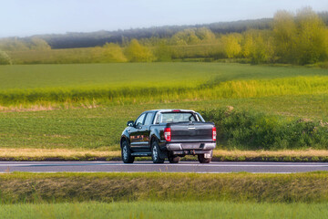 Modern pickup crossing rural farmland at speed © AlexGo