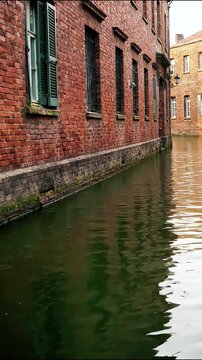 Historical red brick building facade along a narrow urban canal water channel architecture wall city historic river architecture wall city historic river