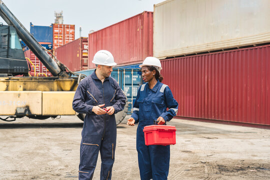 Industrial workers inspecting shipping containers in freight yard logistics distribution depot