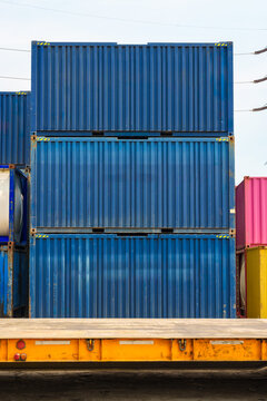 Stacked blue cargo shipping containers in freight terminal yard