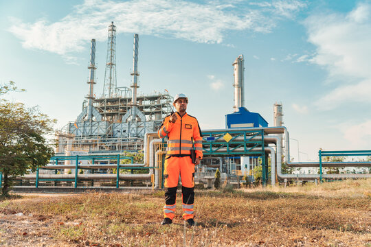 Specialist caucasian technician male in uniform standing at fuel and gas processing station