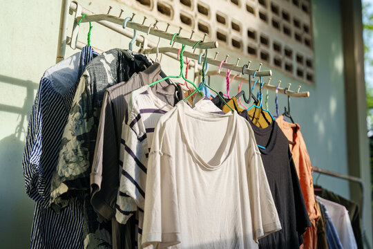 Laundry drying on metal clothes line rack in sunny backyard