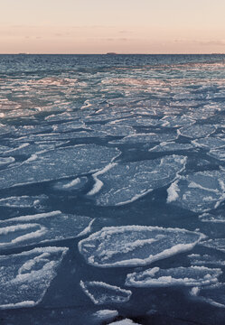 Frozen Pancake Ice Formations on Coastal Sea at Sunset. 