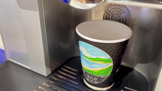 Disposable coffee cup with a green logo on a textured surface, quick beverage moment, urban convenience, on-the-go refreshment.