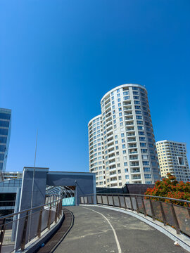 View of modern buildings along a pathway in a city under a clear blue sky during daytime