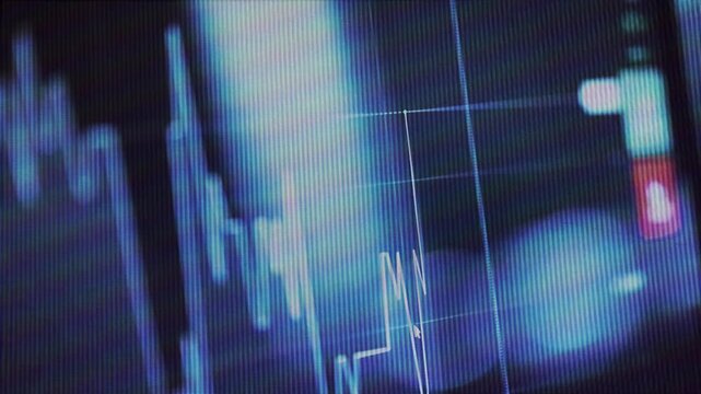 Close-up view of a digital video screen showing a dynamic financial market chart graph