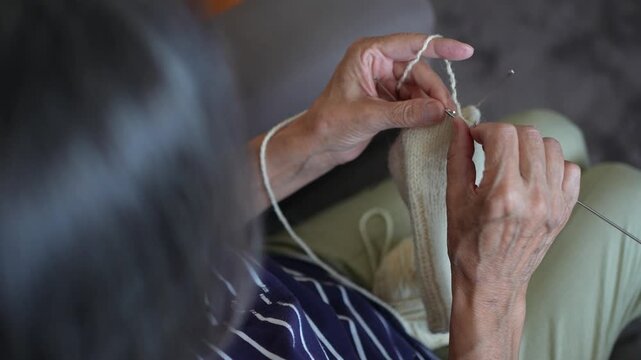 Close-up of an senior woman knitting a wool garment