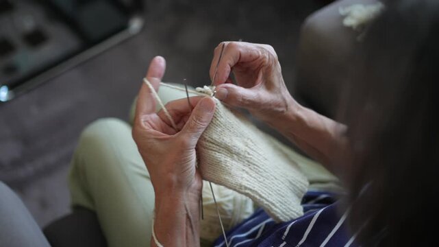 Hands of senior woman knitting with needles