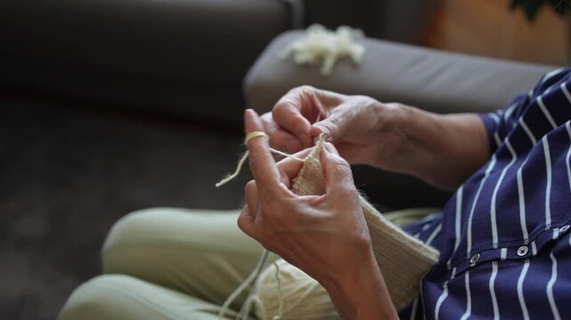 Close-up of an elderly woman hands knitting a wool garment