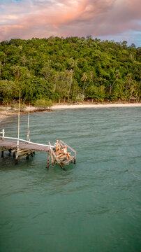 Couple tourist in happiness and relax moment on wooden pier, enjoy the summer trip in tropical island