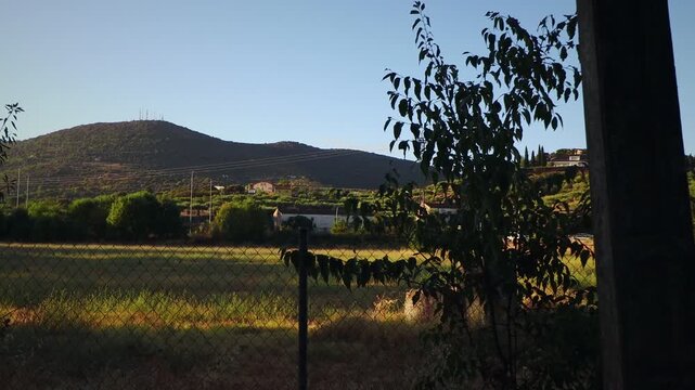 Side tracking shot across a rural landscape with distant mountains in summer
