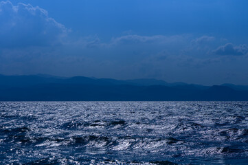 Fototapeta premium Glistening waves at twilight reflect the colors of a serene evening over the vast ocean horizon
