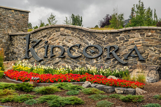Calgary, Alberta, Canada. August 15, 2026. Stone entrance sign for Kincora community with decorative flower beds on cloudy day.