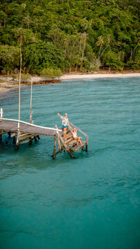Couple tourist in happiness and relax moment on wooden pier, enjoy the summer trip in tropical island