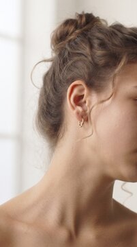 Close-up of a young woman's profile with her eyes closed, showcasing her delicate features