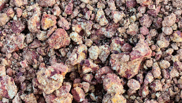 Gravel texture of broken laterite stone and iron-rich red soil clods.