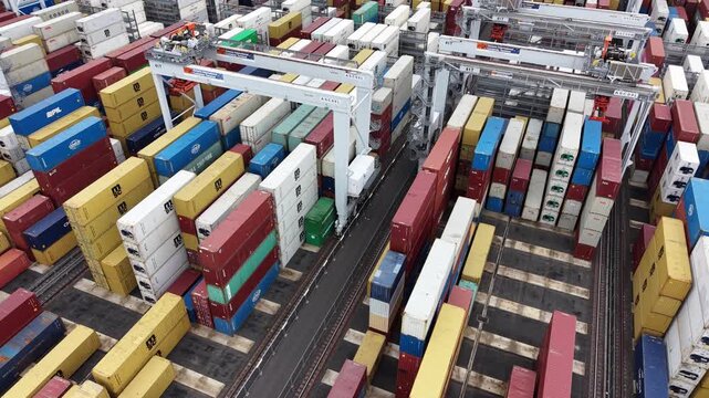 Gantry cranes moving shipping containers at a port terminal