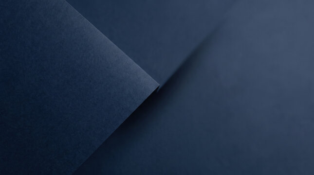 Folded navy paper background with soft shadows creating calm and minimalistic abstract composition