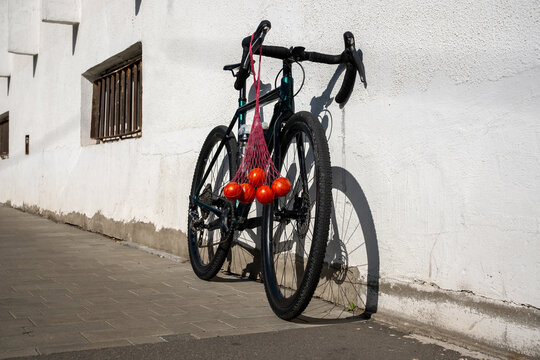 Fresh Tomatoes in a Mesh Bag Hanging from a Bicycle