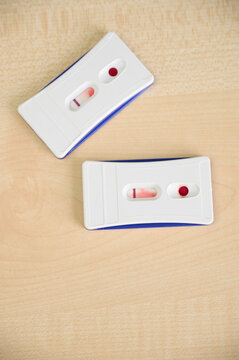 Two veterinary disease tests on a wooden table. The test results are negative.