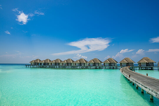 Luxury overwater villas turquoise ocean lagoon tropical island resort blue sky paradise. Perfect summer vacation travel landscape. Exotic Maldives hotel honeymoon getaway relax scenic backdrop