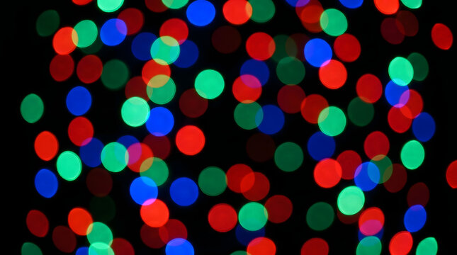 Abstract festive bokeh light circles in red blue and green glowing in the darkness