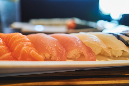 Assorted nigiri sushi with salmon, tuna, and white fish on a plate
